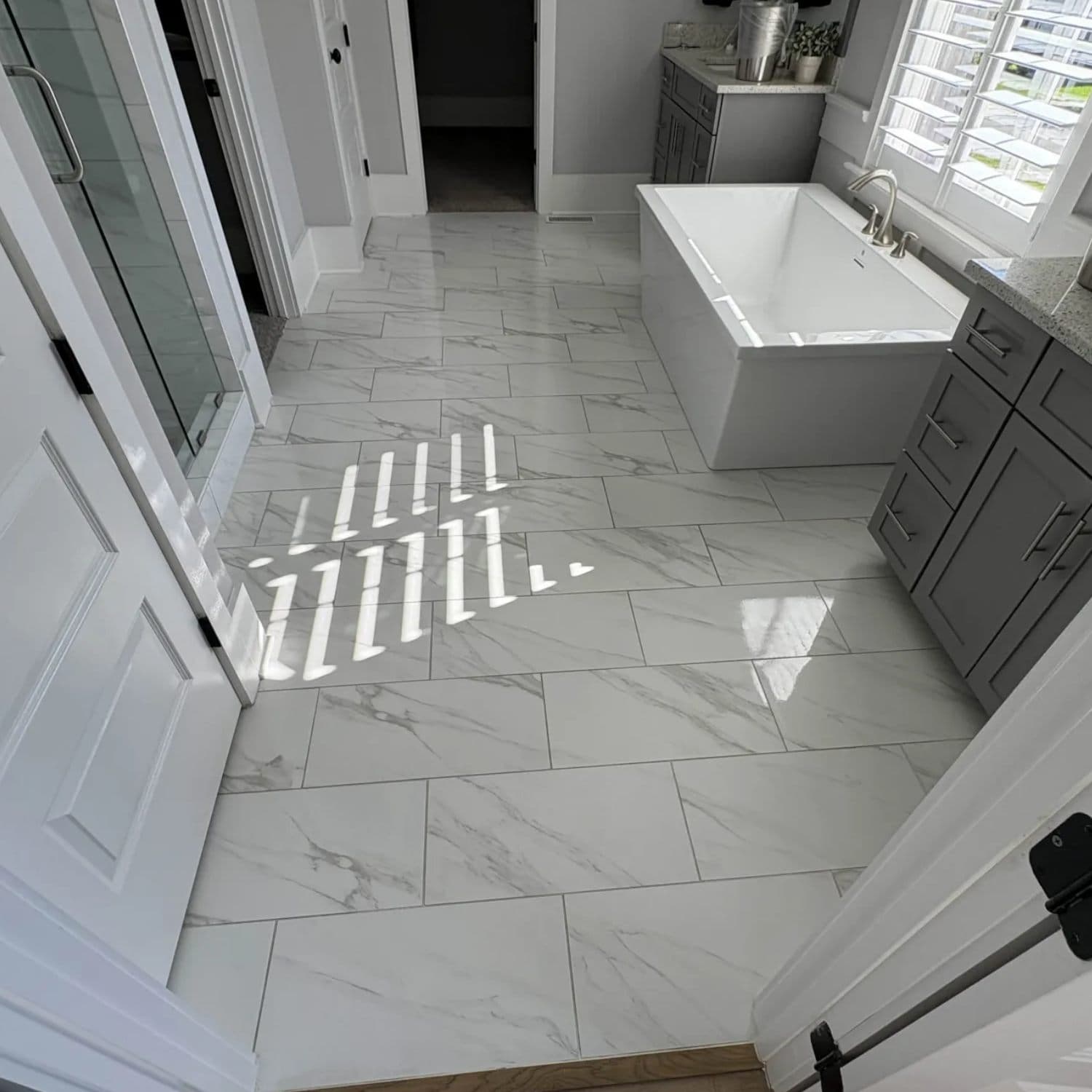 Clean marble-look tiled bathroom floor and walls after professional grout cleaning