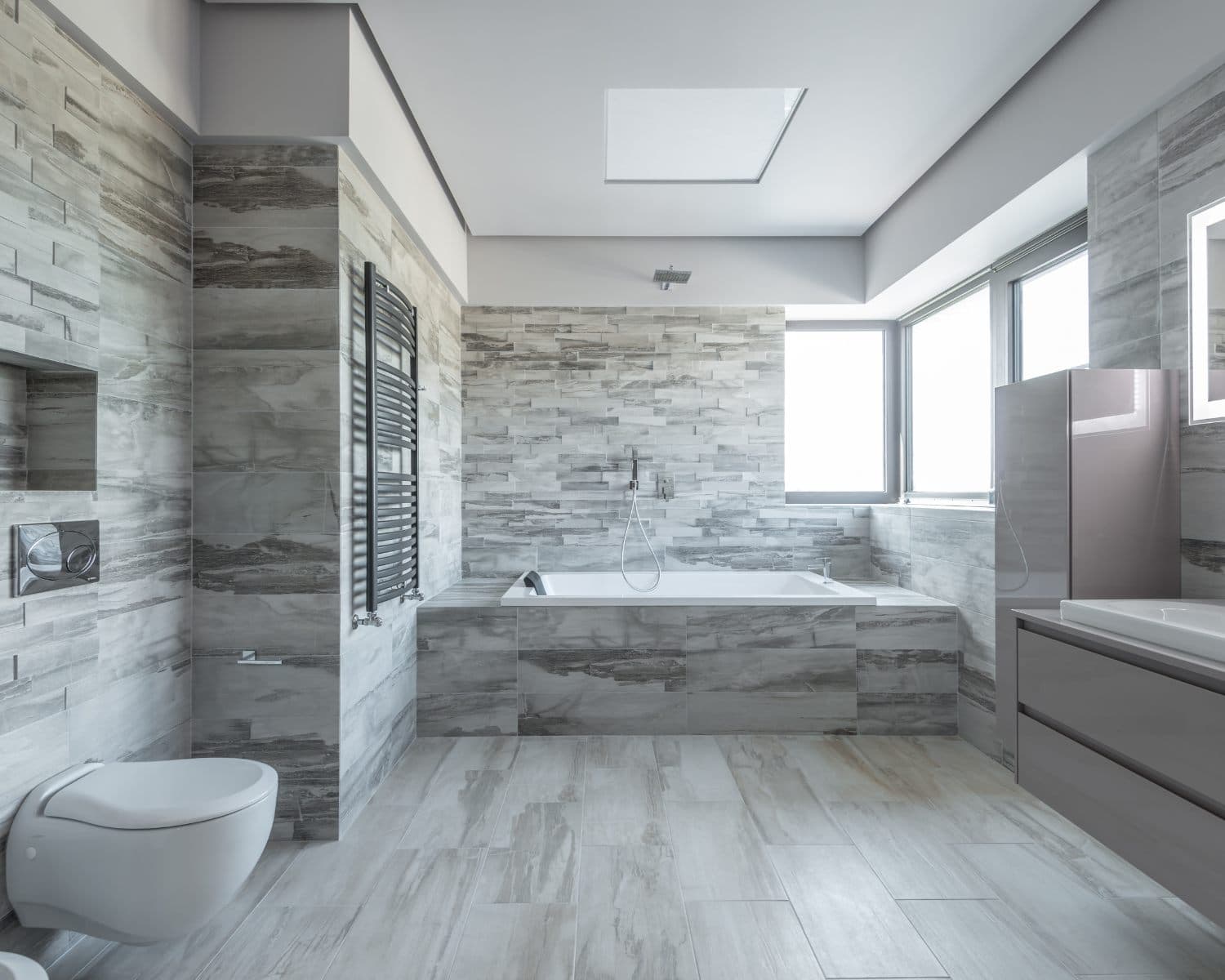 Modern bathroom with clean gray natural-stone tile on the floor and walls